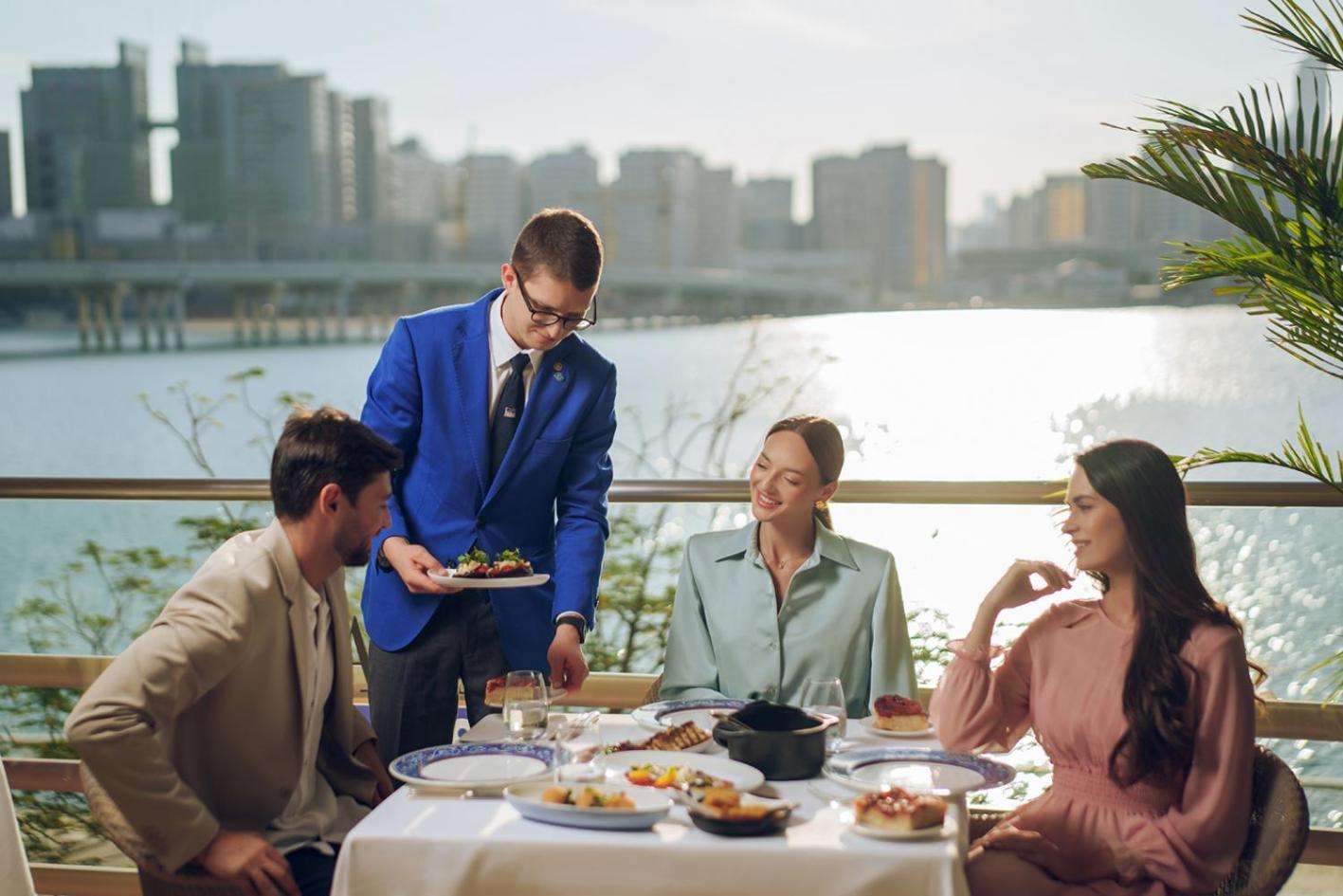 Four Seasons Hotel Abu Dhabi At Al Maryah Island Esterno foto A butler serving food at a restaurant